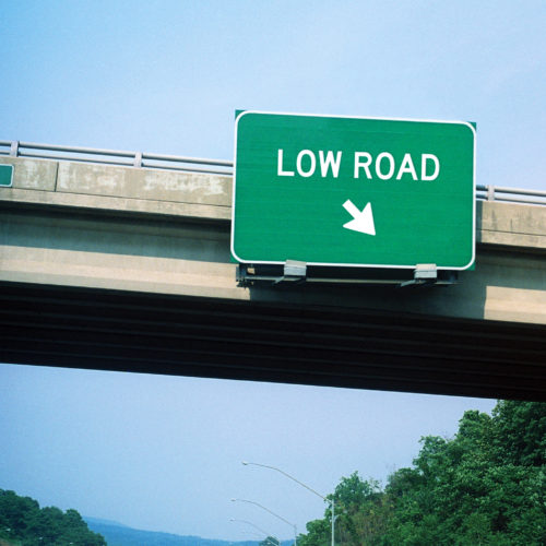 A photograph of a highway sign that says "Low Road."